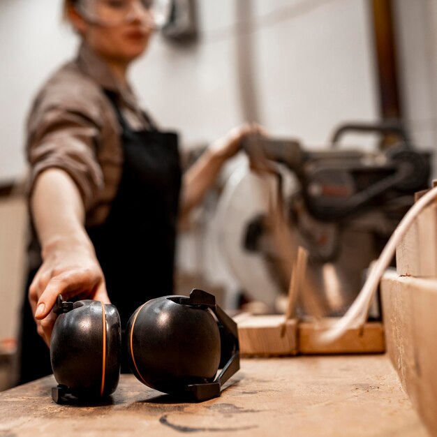 Female carpenter in the studio with headphones