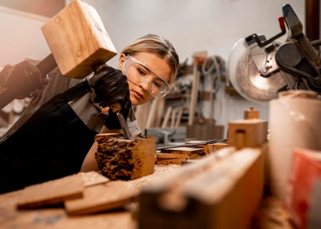 Female carpenter in the studio with wood sculpting tools