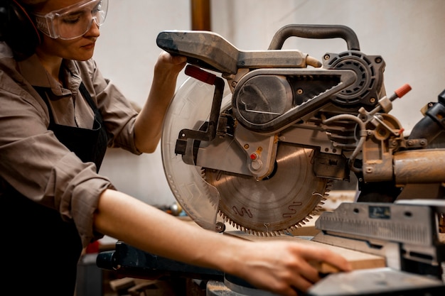 Female carpenter using electric saw