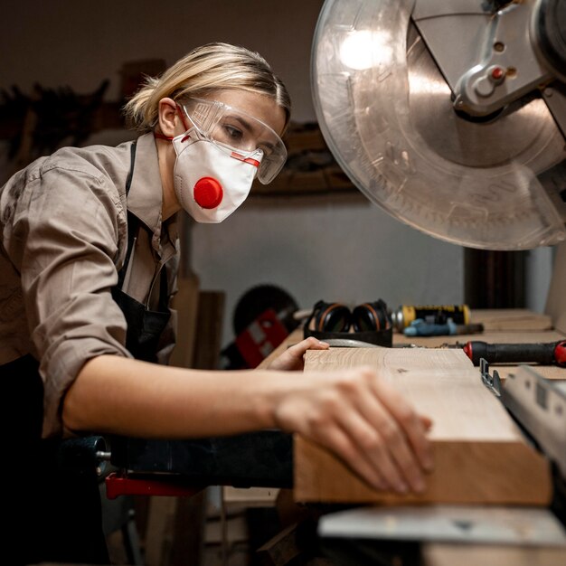 Female carpenter using the round saw