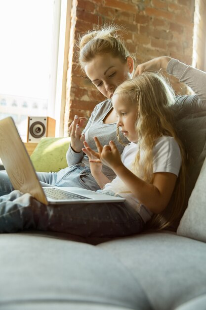 Female caucasian teacher and little girl, or mom and daughter. Homeschooling