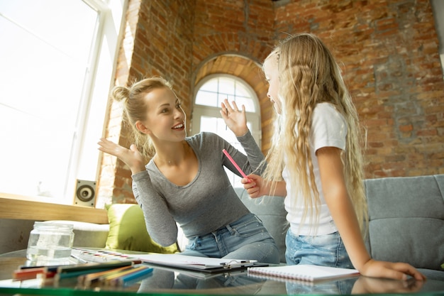 Insegnante caucasico femminile e bambina, o mamma e figlia. istruzione domiciliare