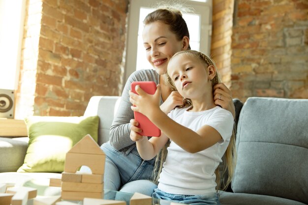 Female caucasian teacher and little girl, or mom and daughter. Homeschooling