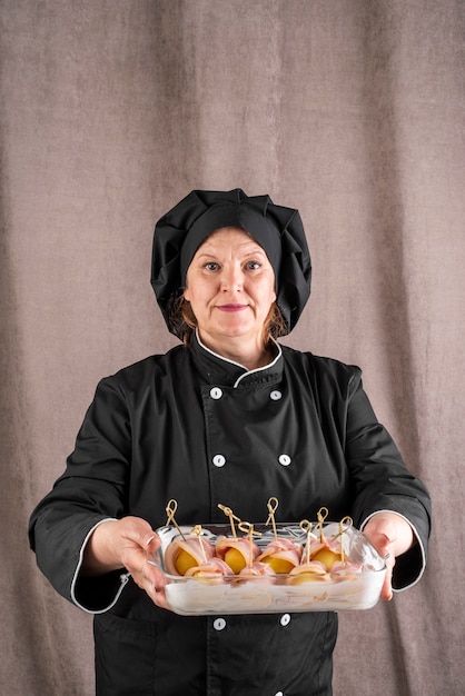 Female chef holding bacon dish