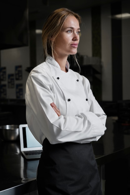 Female chef in the kitchen dressed in apron and uniform