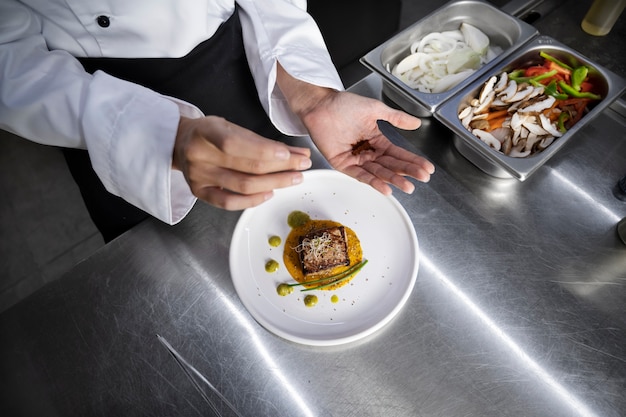 Female chef in the kitchen preparing plate of steak