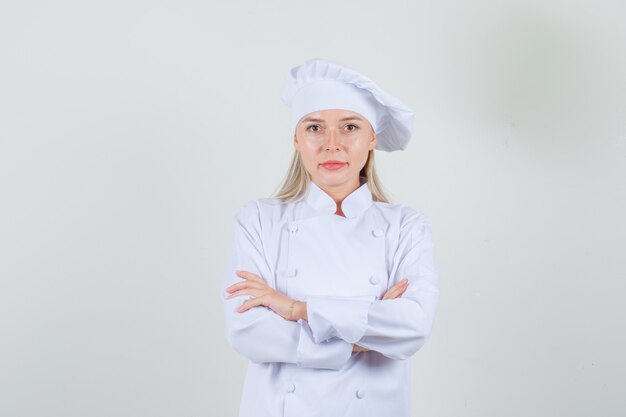 Female chef looking at camera with crossed arms in white uniform and looking positive