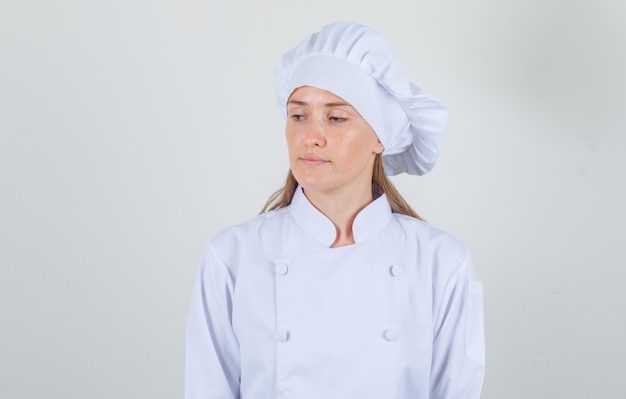 Female chef looking down in white uniform