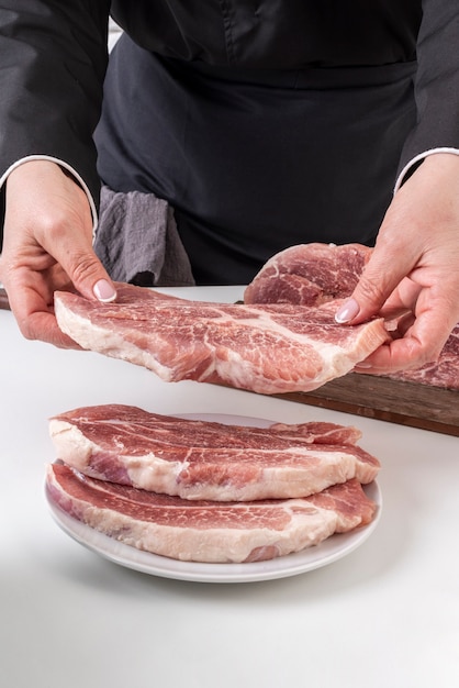 Free photo female chef putting meat on plate