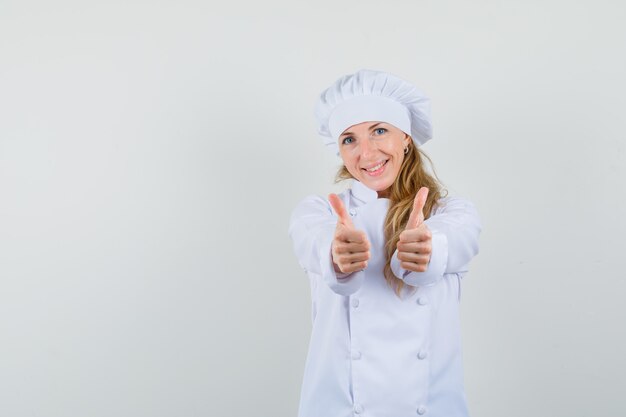 Female chef showing double thumbs up in white uniform and looking cheery 