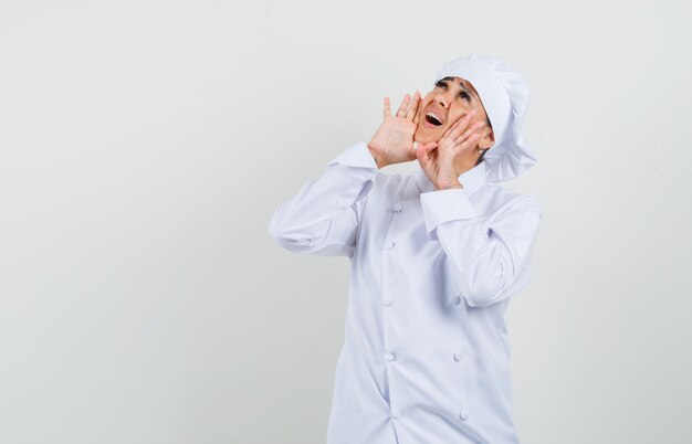 Female chef in white uniform shouting or announcing something