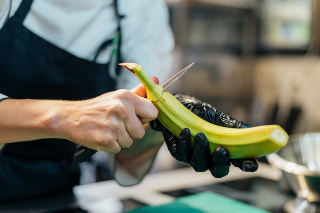 Female chef with glove cutting banana