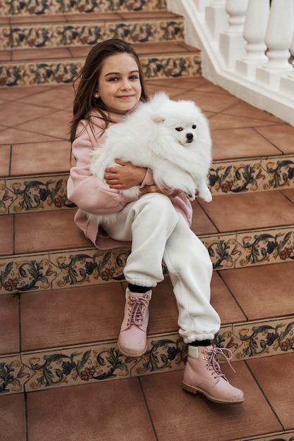 Free photo female child hugging her fluffy companion