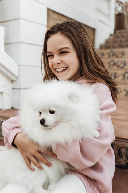 Female child hugging her fluffy dog