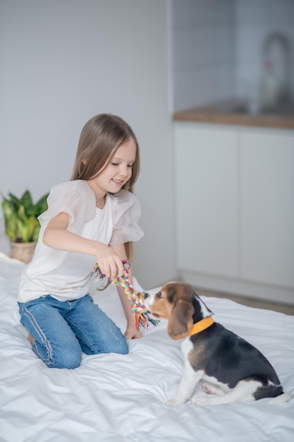 Female child using a rope toy during the dog training