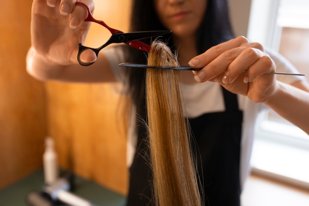 여성 클라이언트 가 이발사 에서 머리카락 을 잘라가고 있다