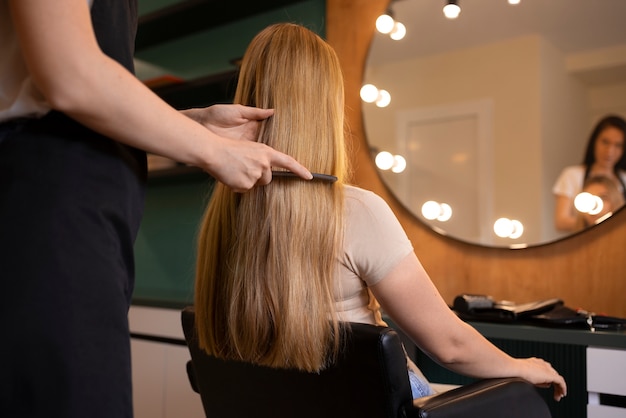 Foto gratuita una cliente si fa fare i capelli dal parrucchiere.