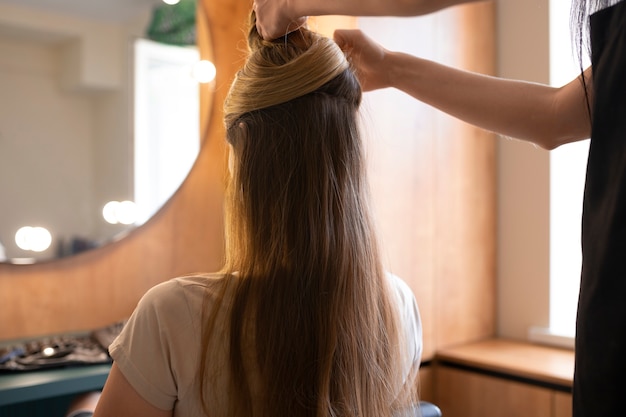 女性のクライアントがヘアドレッサーでを整えています