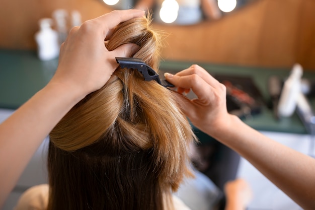 女性のクライアントがヘアドレッサーでを整えています