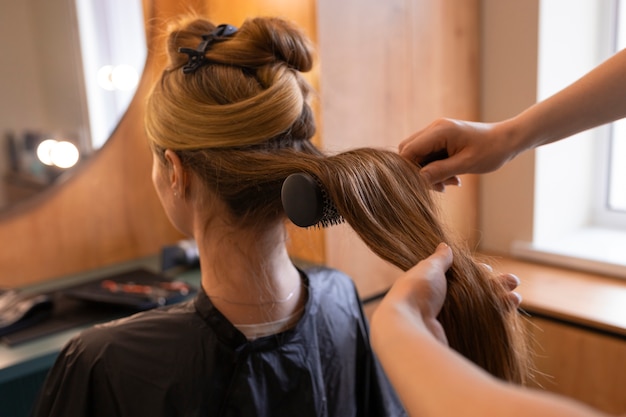 女性のクライアントがヘアドレッサーでを整えています