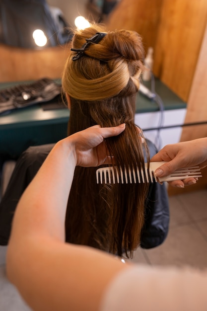 Foto gratuita una cliente si fa fare i capelli dal parrucchiere.