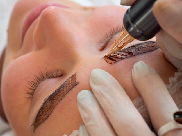 Free photo female client going through a microblading treatment