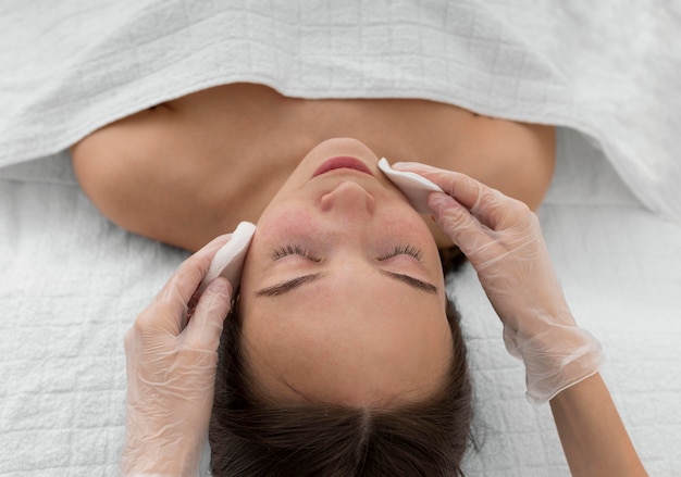 Female client at salon for face care routine with cleansing disks