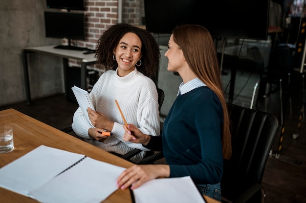 Female colleagues talking to each other during a meeting