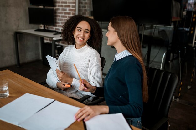 Female colleagues talking to each other during a meeting