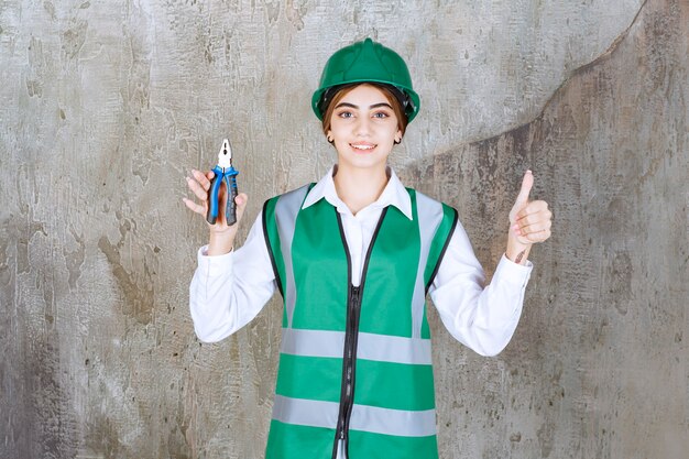 Female contractor pilars on her hand standing and giving thumbs up