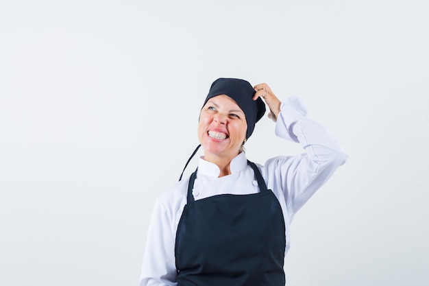 無料写真 制服、エプロン、躊躇している、正面図で頭を掻く女性料理人。