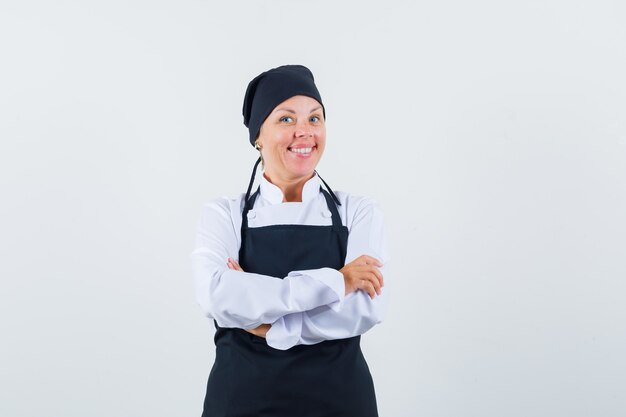여성 요리사 유니폼, 앞치마에 팔을 교차 서 행복, 전면보기를 찾고.