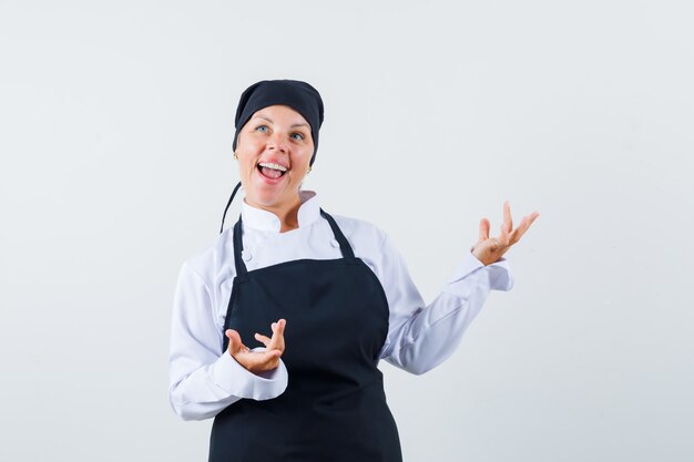 制服を着た女性料理人、手を上げて幸せそうに見えるエプロン、正面図。