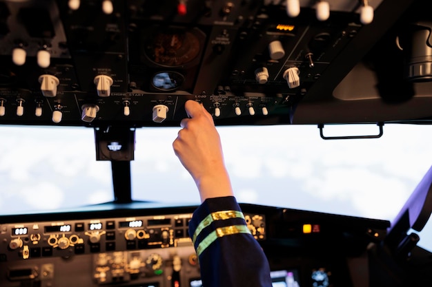 Copilota femmina premendo i pulsanti e l'interruttore sul pannello del cruscotto, aereo in volo con navigazione e comando di controllo. utilizzo della leva del motore elettrico e della bussola radar per il decollo con l'aereo. avvicinamento.