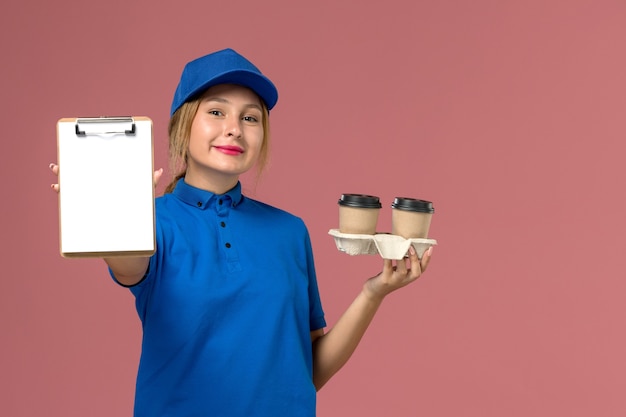 분홍색, 서비스 작업자 유니폼 배달에 커피와 메모장의 배달 컵을 들고 파란색 유니폼 여성 택배