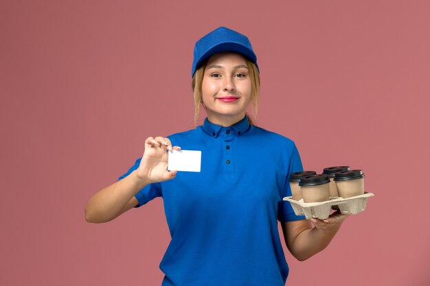 흰색 카드와 분홍색, 서비스 작업 유니폼 배달 노동자에 커피 갈색 배달 컵을 들고 파란색 유니폼 여성 택배