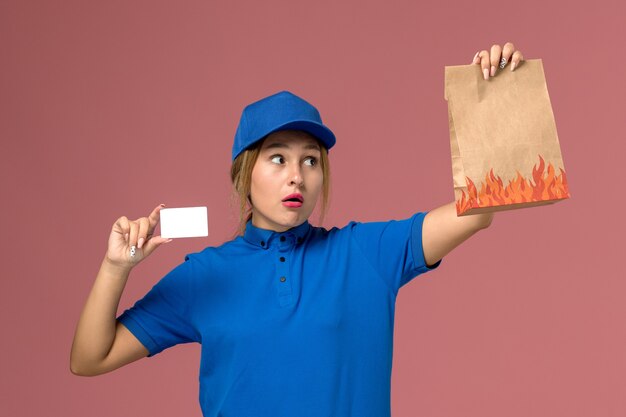밝은 분홍색, 서비스 유니폼 배달 작업에 흰색 플라스틱 카드와 음식 패키지를 들고 파란색 유니폼 여성 택배