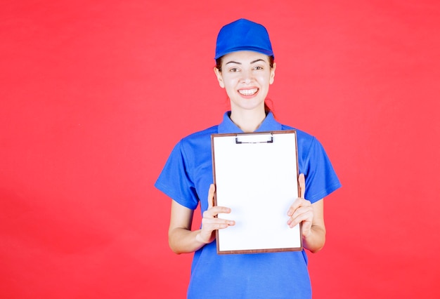 Foto gratuita corriere femminile in uniforme blu che presenta l'elenco delle firme.