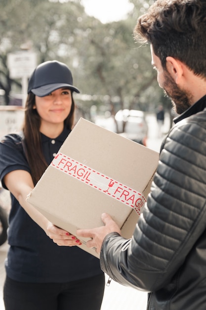 Free photo female courier delivering parcel to man