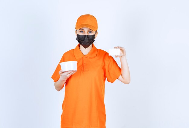 주황색 제복을 입은 여성 택배와 플라스틱 컵을 들고 명함을 제시하는 검은색 마스크