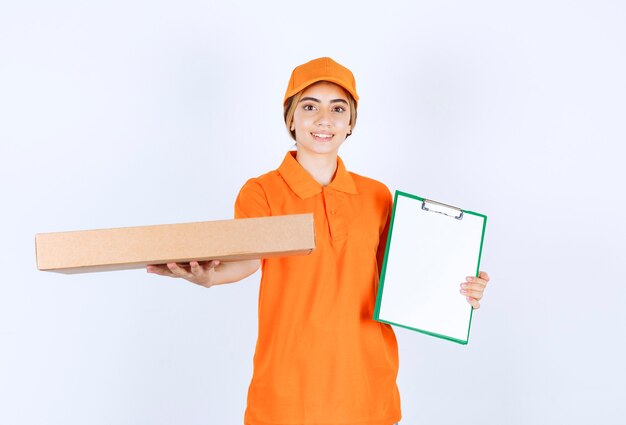 판지 상자를 들고 서명 목록을 제시하는 주황색 제복을 입은 여성 택배