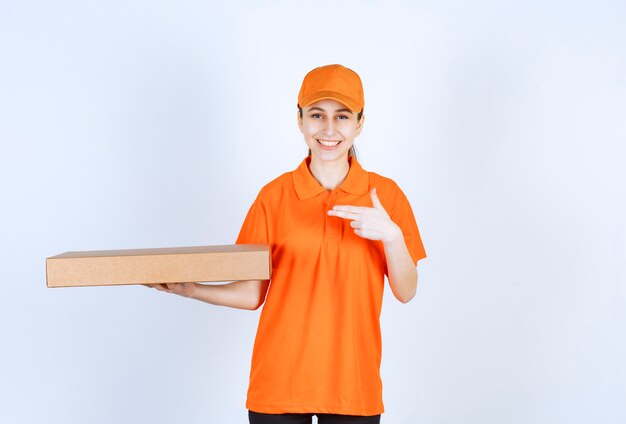 Female courier in orange uniform holding a takeaway pizza box