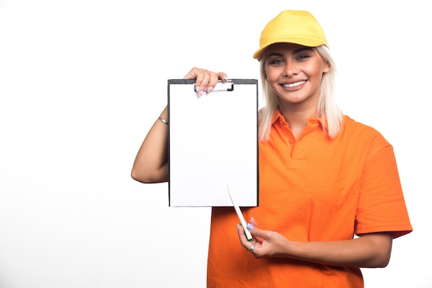 Female courier pointing at empty notebook on white background. High quality photo