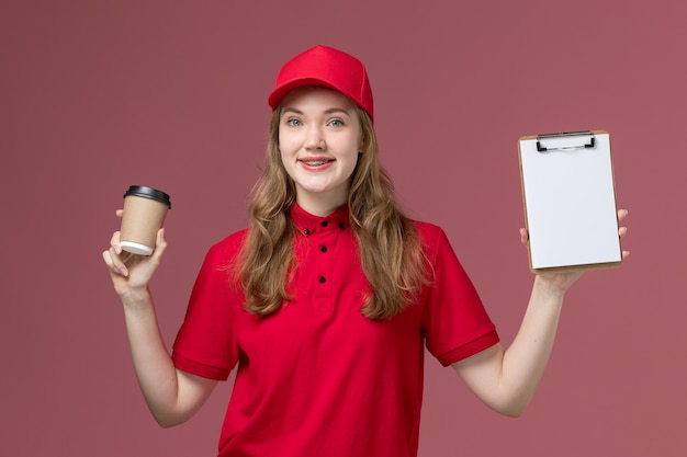 ピンクの制服サービス提供の仕事の労働者にコーヒーカップとメモ帳を保持している赤い制服の女性の宅配便