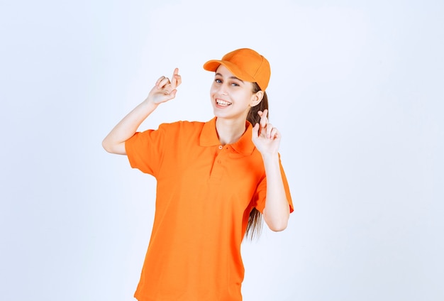 Женский курьер в оранжевой форме и кепке