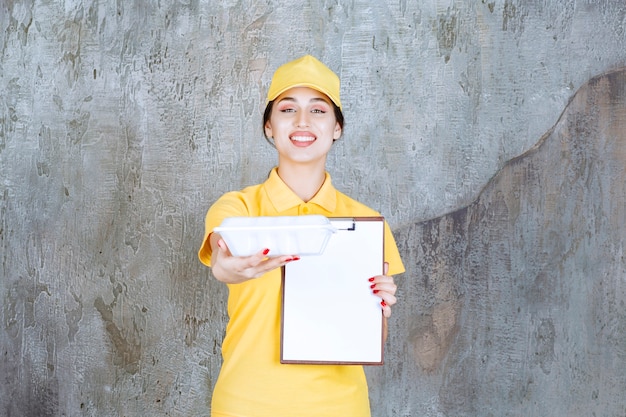 Female courier wearing yellow uniform delivering a takeaway box and asking for signature