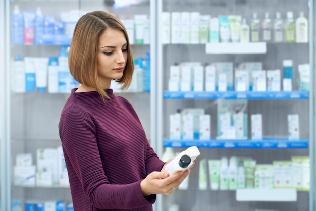 Female customer choosing medical products in drugstore