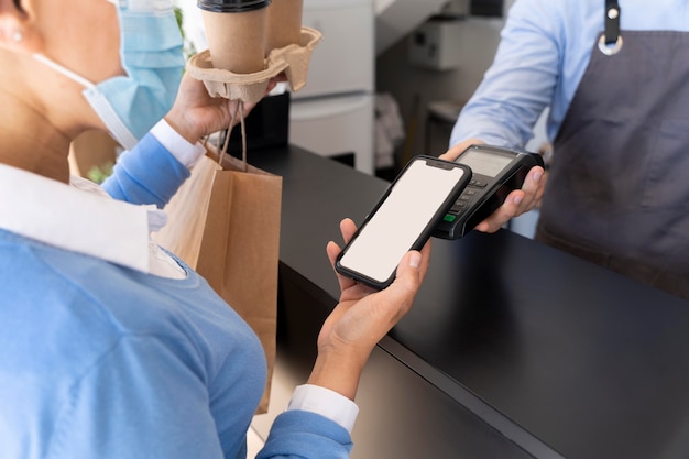 Free photo female customer paying for takeaway food with smartphone