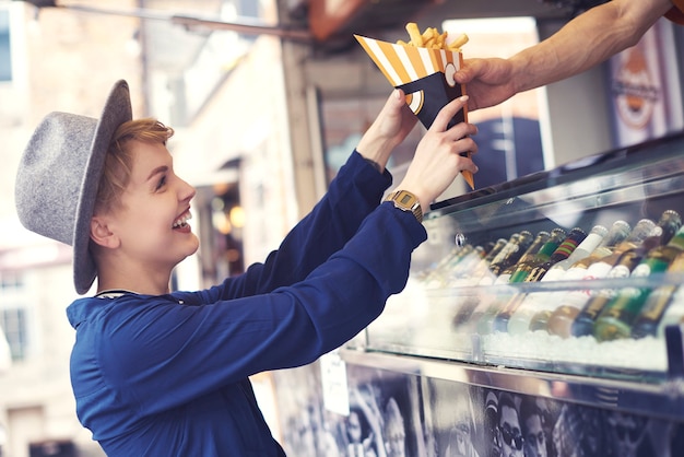 Female customer reaching food from vendor