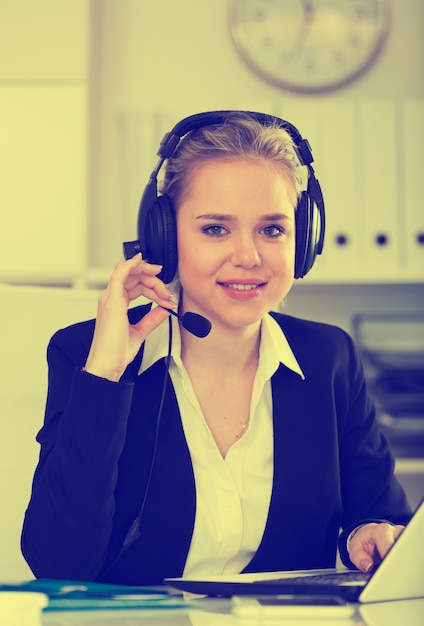 Foto gratuita operatore telefonico di supporto del cliente femminile sul posto di lavoro